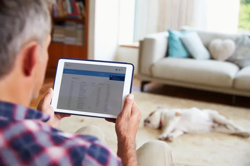 Man Looking At Banking App On Digital Tablet